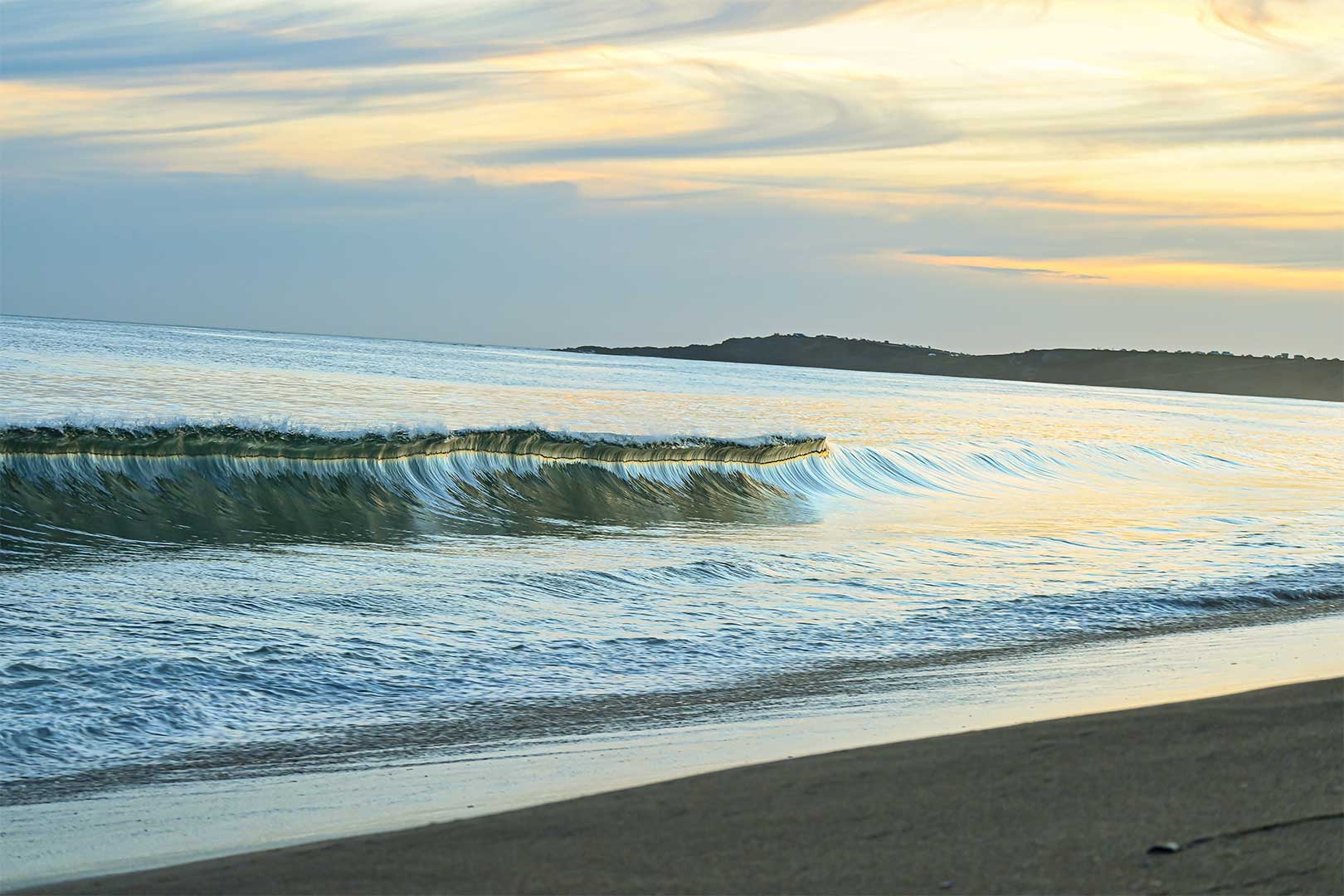 Ola rompiendo en una playa de Uruguay al atardecer