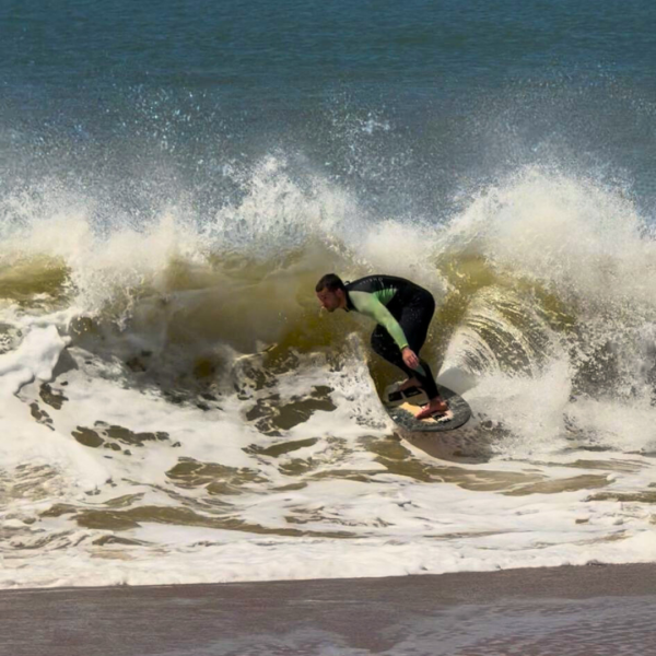 Rider de skimboard girando en una ola